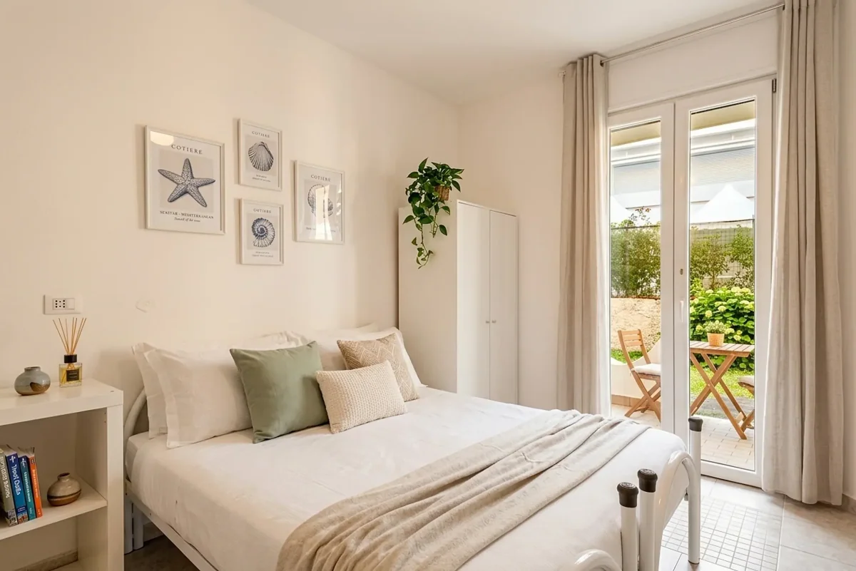 Camera da letto luminosa con portafinestra sul giardino, in un appartamento a Chioggia