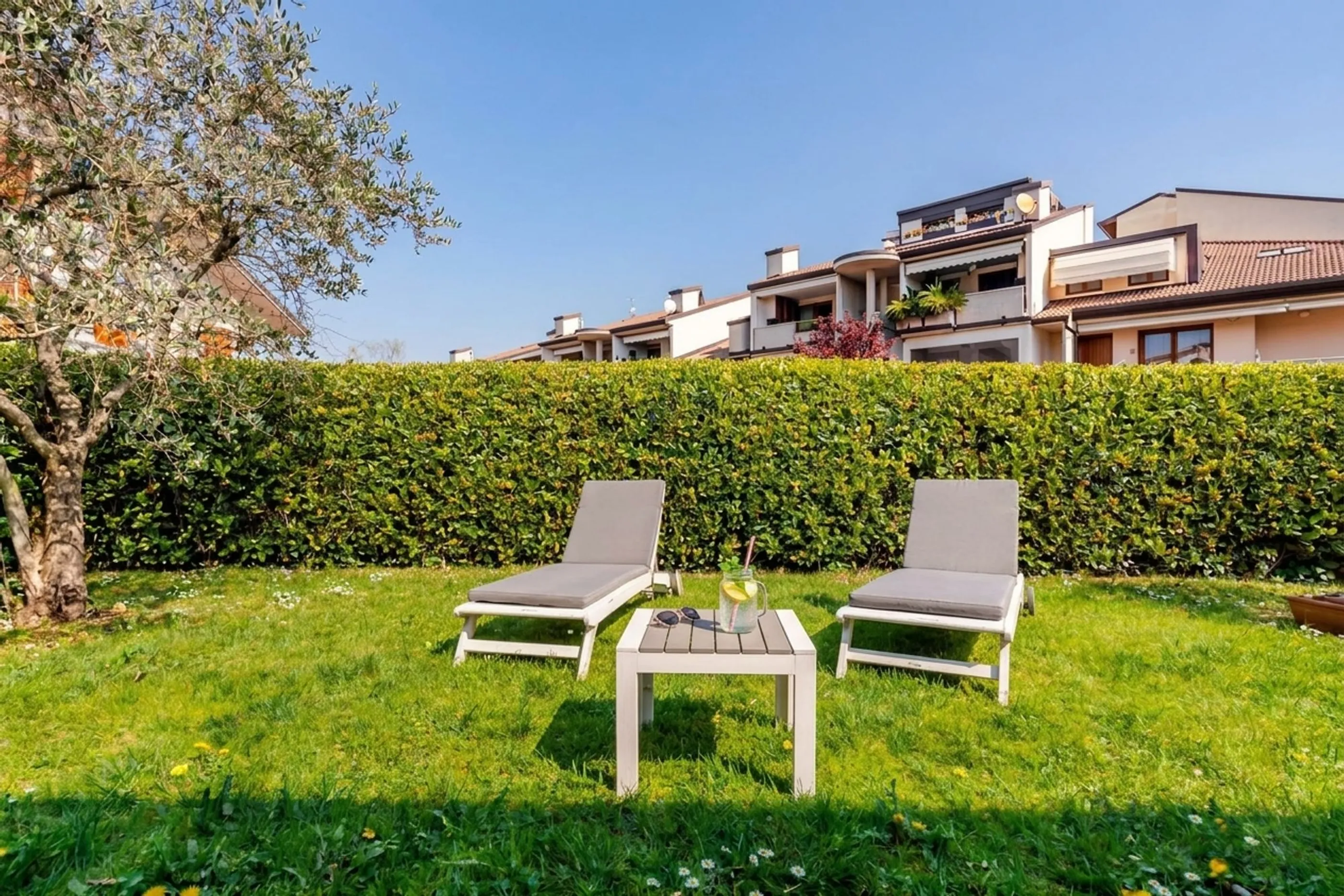 Giardino con due lettini e un tavolino sul prato, in un immobile a Desenzano
